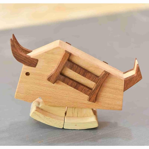 A hand-assembled wooden kinetic toy that recreates an ancient Chinese mechanical chariot — the ox actually walks when it rolls.
