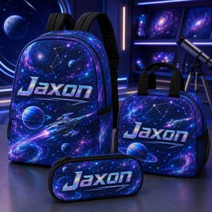 May include: A backpack, a lunch bag, and a pencil case featuring a dark blue space theme with nebulae, planets, and a spaceship. Each item displays the name Jaxon in a stylized, metallic-effect font across the front, set against a starry background.