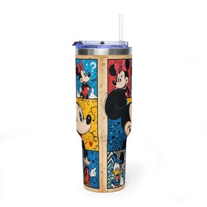 May include: A stainless steel tumbler with a comic strip design featuring Mickey and Minnie Mouse. The tumbler has a blue lid and a clear straw. The artwork uses bright colours and classic Disney characters.
