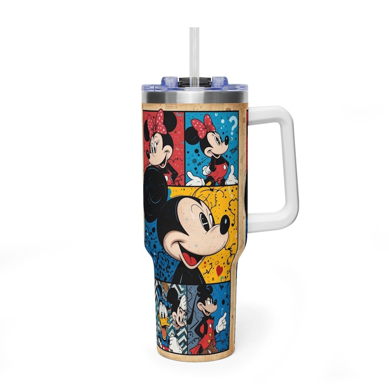 May include: An insulated travel mug with a comic strip design featuring Mickey and Minnie Mouse. The mug has a white handle, a clear lid, and a white straw. The artwork is in primary colours with a vintage comic book style.