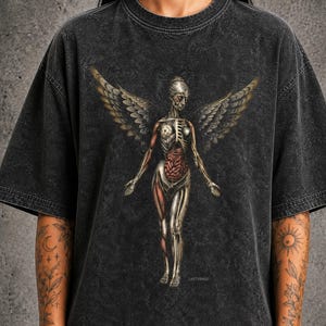 May include: A charcoal grey acid-wash t-shirt featuring a graphic print of an anatomical winged figure with exposed internal organs and skeletal structure. The design includes the text LASTVIRAGE printed in small white letters below the figure.