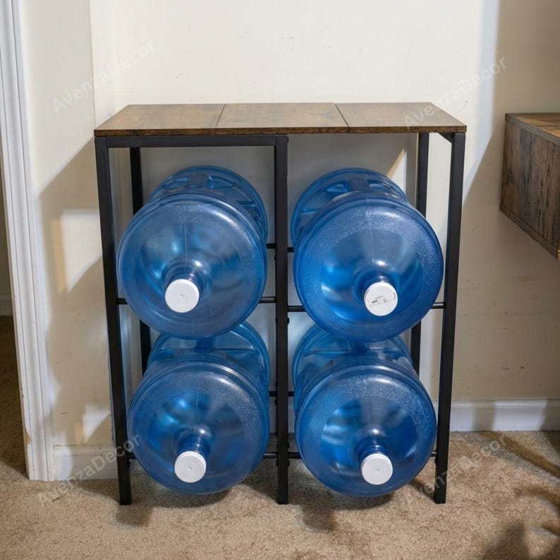 May include: A black metal storage rack with a brown wood-grain top surface, designed to hold four large blue plastic water jugs. The rack features a rectangular frame with two vertical sections, each accommodating two stacked water containers.