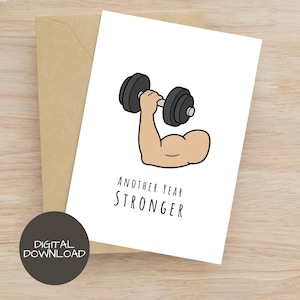 Puede incluir: Una tarjeta de felicitación blanca con una ilustración de dibujos animados de un brazo musculoso levantando una mancuerna negra. Debajo de la ilustración, el texto "ANOTHER YEAR STRONGER" aparece en una fuente negra sencilla sin remates.