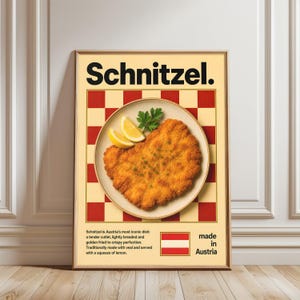 May include: A framed poster with the word "Schnitzel" in black. The image displays a golden-brown, breaded cutlet on a plate with lemon slices and parsley. The background has a red and cream checkerboard pattern, with text and the Austrian flag.