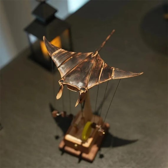 A handcrafted wooden manta ray that actually flies — motorized kinetic automaton with undulating wings that turns any desk into an ocean floor.