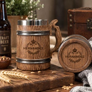 May include: A brown beer mug with a wood grain texture, a silver metal rim, and a matching handle. The mug features a dark brown engraved logo with a crown icon and the text HERNANDEZ surrounded by a laurel wreath design on the front.