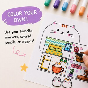 May include: A coloring page featuring a cat-shaped house with multiple rooms, including a bedroom, kitchen, and living area. The text reads COLOR YOUR OWN! and Use your favorite markers, colored pencils, or crayons! A yellow star and markers are visible.