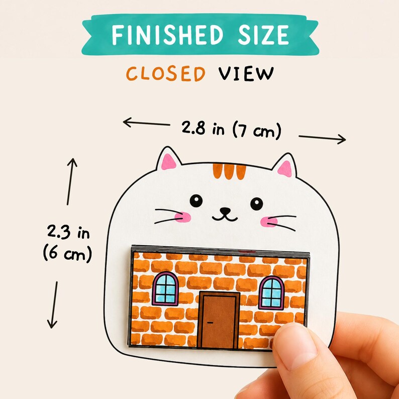 May include: A white cat-shaped paper cutout with orange stripes on its head, pink cheeks, and a brick house illustration on its body. Text reads FINISHED SIZE and CLOSED VIEW. Dimensions are 2.8 inches wide by 2.3 inches tall.