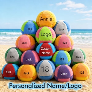 May include: A pyramid of colorful beach balls with personalized text. Each ball features a different color combination and text such as "Annie", "Jack", "123", "Logo", "Custom Name", and "18". The balls are arranged on a sandy beach with the ocean in the background.