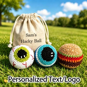 May include: A beige drawstring pouch with the text Sam's Hacky Ball printed on the front, accompanied by three crocheted balls: one white with a green iris and red veins, one blue with a black iris, and one resembling a hamburger with layers.