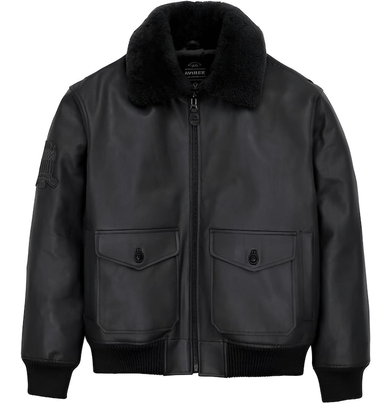 May include: A black leather bomber jacket featuring a black faux fur collar, a full-length front zipper, and two large front pockets with buttoned flaps. The jacket includes ribbed cuffs and a ribbed hem, with a patch on the right sleeve.