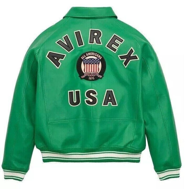 Pode incluir: Uma jaqueta universit&aacute;ria de couro verde brilhante com gola, mangas compridas e punhos e bainha canelados com listras brancas. A parte de tr&aacute;s exibe o texto AVIREX em preto, um emblema circular com uma bandeira dos EUA e o texto USA.
