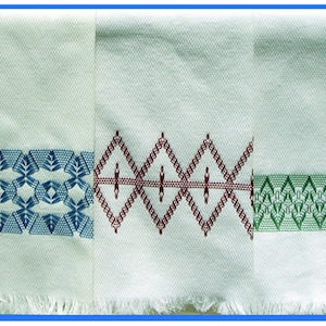 May include: Three white kitchen towels with embroidered borders. The towel on the left has a blue geometric pattern, the middle towel has a red diamond pattern, and the towel on the right has a green geometric pattern.