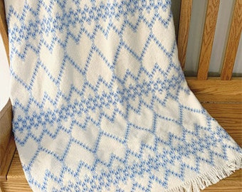 May include: White throw blanket with a blue diamond pattern and fringe trim.
