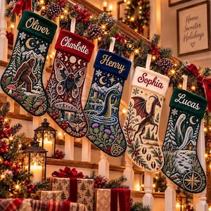 Op de afbeelding: Vijf gepersonaliseerde kerstsokken hangen op een rij, elk met unieke geborduurde mythische wezens zoals Bigfoot, een mot, het monster van Loch Ness, een draak en geesten, met de namen Oliver, Charlotte, Henry, Sophia en Lucas.