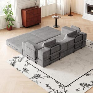 May include: A modular gray corduroy sofa bed featuring a textured fabric finish, black metal frame supports on the back and sides, and multiple rectangular cushions. The piece is configured in a partially extended position with a flat sleeping surface.