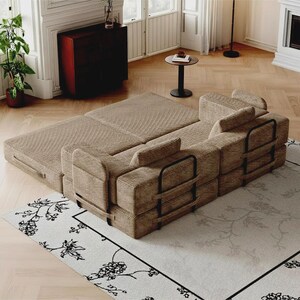 May include: A modular sofa bed upholstered in tan corduroy fabric, featuring a low-profile design with black metal frame supports on the sides. The sofa is configured in a partially extended position, showcasing its rectangular cushions and structure.
