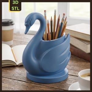 May include: A matte blue swan-shaped pencil holder with a rounded base, featuring a hollow interior currently holding a collection of various coloured pencils. The object is labelled with a yellow tag in the upper left corner reading 3D STL.