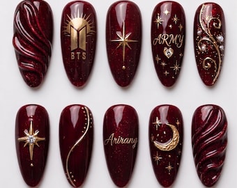 Unhas postiças douradas e vermelhas do BTS - Bordô escuro com glitter, sol, estrelas e inscrição ARMY, textura em espiral, formato estilete.