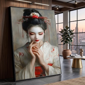 May include: A framed portrait of a woman in traditional Japanese attire. The woman has pale skin, red lips, and dramatic eye makeup. She wears a white kimono with red floral patterns and a red obi. Her hair is styled in a traditional updo with floral and decorative hairpieces.