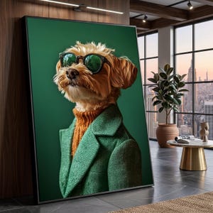Può includere: Ritratto incorniciato di un cane con occhiali da sole, un maglione arancione e un blazer verde. Il cane ha il pelo marrone chiaro ed è ambientato su uno sfondo verde scuro. L'immagine è esposta in un ambiente interno moderno.