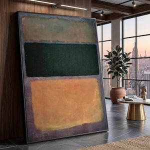 May include: Abstract art print featuring three horizontal blocks of color. The top block is a muted green, the middle is a deep forest green, and the bottom is a warm orange. The artwork is framed in black and leans against a wall.
