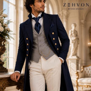 May include: A navy blue double-breasted long coat with gold buttons, a grey waistcoat, a white dress shirt, and a navy blue necktie. A gold pocket watch chain is attached to the waistcoat. The text Z E H V O N BEYOND ORDINARY is visible.