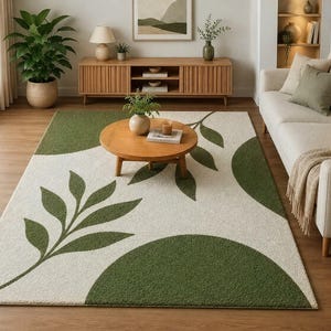 May include: A rectangular area rug featuring a cream-colored background with large, solid olive green circular shapes and stylized green leaf patterns extending across the surface. The rug has a textured, tufted pile construction.