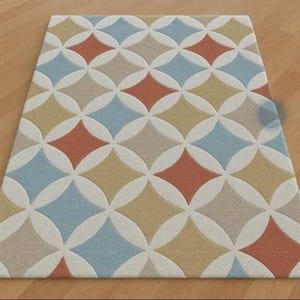Peut inclure: Un tapis rectangulaire présentant un motif géométrique répétitif de cercles et de losanges entrelacés. Le design intègre une palette de formes orange sourd, bleu doux, beige et ocre sur un fond de couleur crème.