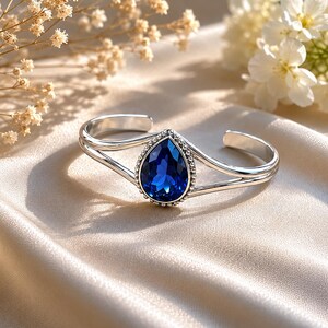 Pulseira rígida prateada com pingente de gota de safira azul royal
