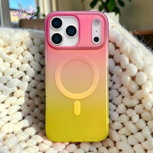 Puede incluir: Una funda rectangular para smartphone con un degradado de color vertical que va del rosa en la parte superior al naranja en el centro y al amarillo en la parte inferior. La funda incluye un anillo magn&eacute;tico MagSafe circular y una abertura.