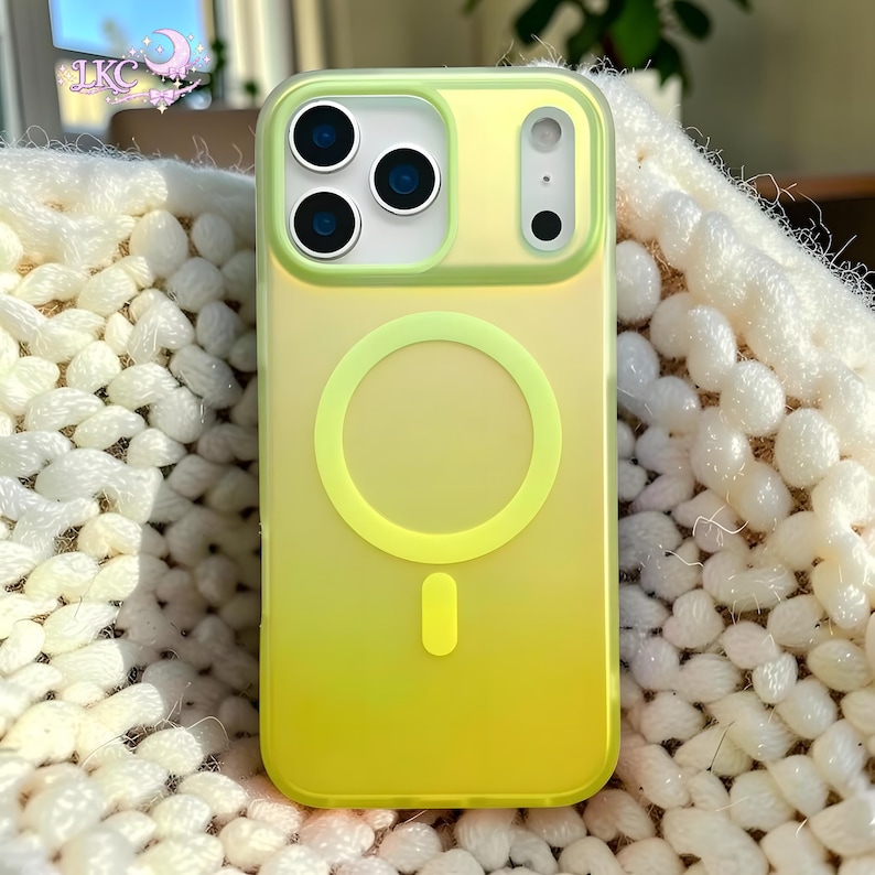 Puede incluir: Una funda para smartphone con un degradado en amarillo y verde lima. La funda presenta un anillo magn&eacute;tico MagSafe circular y un im&aacute;n de alineaci&oacute;n vertical en el centro. El &aacute;rea de la c&aacute;mara est&aacute; elevada con tres aberturas circulares.