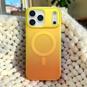 Puede incluir: Una funda de tel&eacute;fono con degradado amarillo y naranja que presenta un anillo magn&eacute;tico MagSafe circular y un im&aacute;n de alineaci&oacute;n vertical en la parte posterior. La funda tiene un recorte rectangular para la c&aacute;mara con tres aberturas.