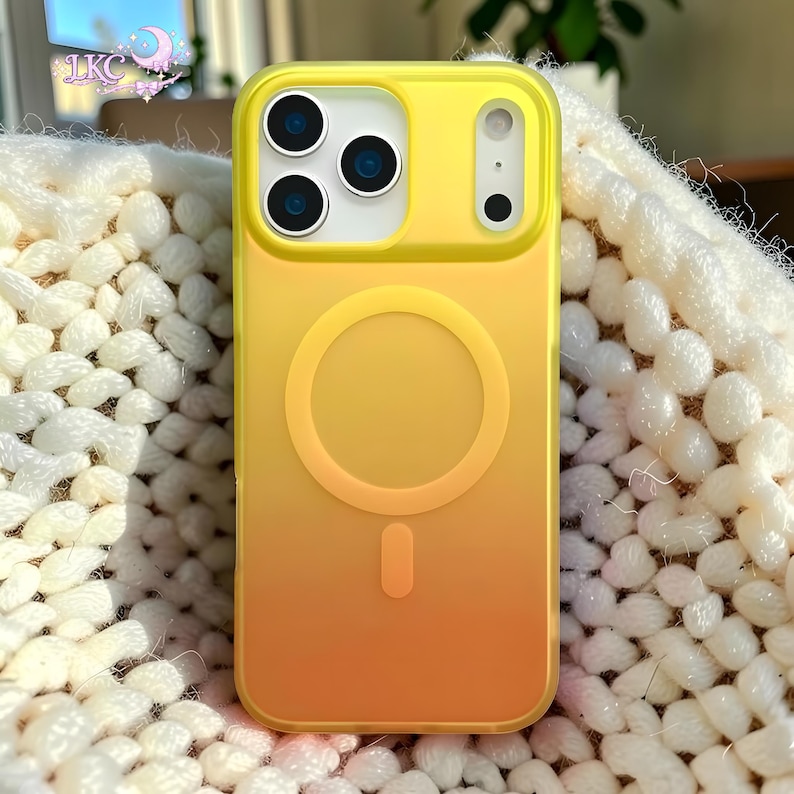 Puede incluir: Una funda de tel&eacute;fono con degradado amarillo y naranja que presenta un anillo magn&eacute;tico MagSafe circular y un im&aacute;n de alineaci&oacute;n vertical en la parte posterior. La funda tiene un recorte rectangular para la c&aacute;mara con tres aberturas.