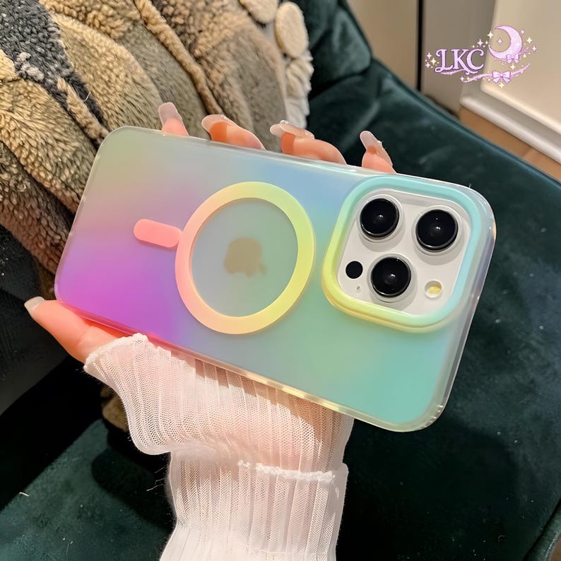 Puede incluir: Una funda de smartphone transl&uacute;cida con un suave degradado de colores pastel que transita del rosa al amarillo y al azul claro. La funda incluye un anillo de carga magn&eacute;tico circular en la parte posterior y un marco elevado alrededor de la triple c&aacute;mara.