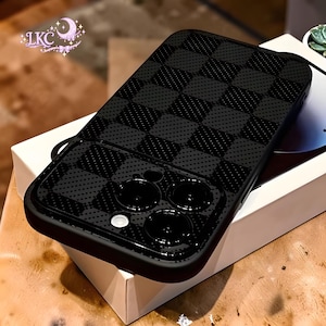 Puede incluir: Una funda de smartphone negra con un patrón de cuadros oscuros y una textura de puntos sutil. La funda incluye un recorte para un sistema de cámara de triple lente y un flash. Un logotipo con el texto LKC y una luna es visible en la esquina.