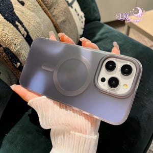 Puede incluir: Una funda para smartphone transl&uacute;cida con acabado mate en un suave tono lavanda, que presenta un anillo magn&eacute;tico MagSafe circular en la parte posterior y un recorte elevado para el m&oacute;dulo de la c&aacute;mara. La funda tiene una textura suave.