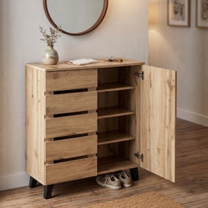 May include: A wooden shoe cabinet with a light brown finish. The cabinet has five drawers on the left side and shelves on the right, with the door open. A pair of sneakers sits inside. The cabinet is on black legs.