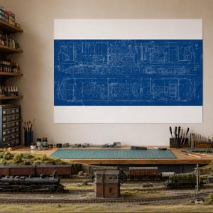 May include: A large rectangular wall print featuring a detailed white technical blueprint of a locomotive train engine on a solid blue background, displayed above a model train layout with miniature tracks, buildings, and train cars.