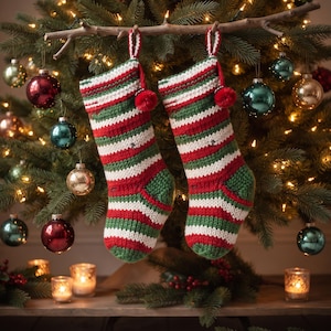 Peut inclure: Deux chaussettes de Noël assorties présentant un motif à rayures horizontales rouges, blanches et vertes. Chaque chaussette est confectionnée avec une texture tricotée, inclut un petit pompon rouge près de l'ouverture et une boucle.