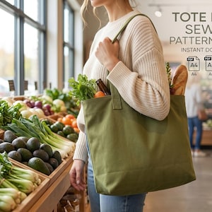 May include: A solid olive green canvas tote bag with two shoulder straps. The text TOTE BAG SEWING PATTERN PDF INSTANT DOWNLOAD is visible along with icons for A4, A0, and US Letter paper sizes. The bag is filled with fresh produce and bread.