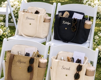 May include: Four canvas tote bags in cream, black, and tan colors, each personalized with embroidered names Brianna, Katelyn, Alyssa, and Sarah. Each bag features a front pocket with a gold snap, side pockets with tumblers, and interior items.