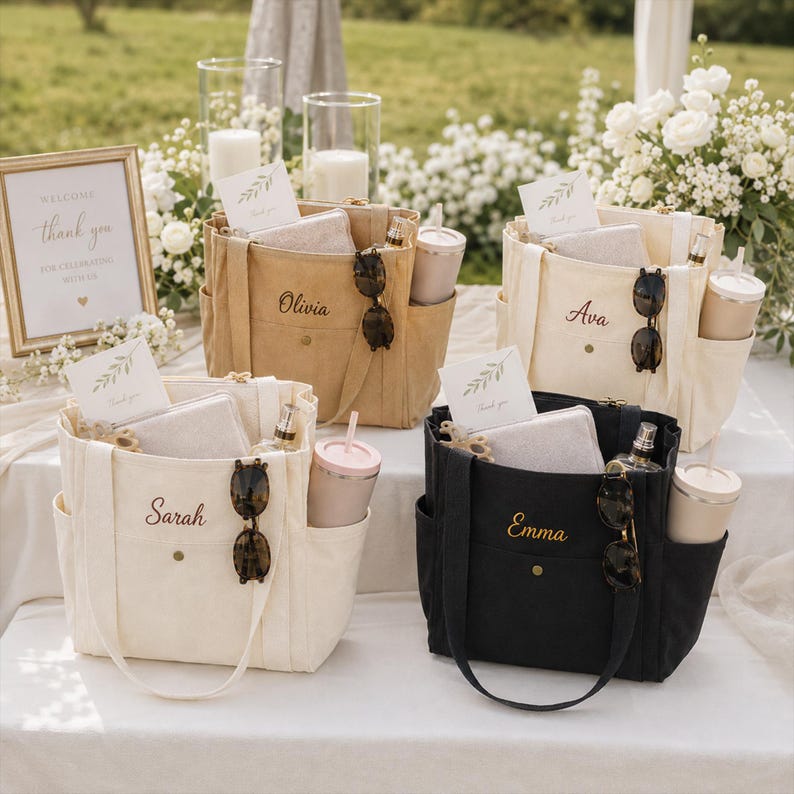 May include: Four canvas tote bags in tan, cream, and black, each featuring a front pocket with a snap closure, side pockets, and embroidered names: Olivia, Ava, Sarah, and Emma. Each bag contains a card, a pouch, sunglasses, and a tumbler.