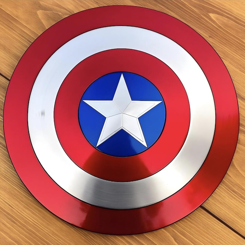 May include: A circular shield featuring a concentric design with a metallic red outer ring, a silver middle ring, and a central blue circle containing a large, five-pointed white star. The surface has a smooth, reflective finish throughout.