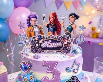 May include: A two-tier cake with purple, blue, and white frosting, decorated with a glittery purple number 3, K-pop character cutouts, a sign reading Anna, and a K-pop Demon Hunters logo. The cake features musical note and star accents.