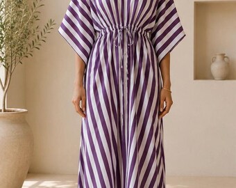 Vestido maxi estilo caftan listrado em roxo e branco, em algodão, ideal para usar como saída de praia ou roupa de descanso.
