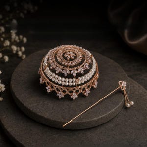 Könnte beinhalten: Ein Haarschmuck-Set in Roségold, bestehend aus einem kuppelförmigen Dutt-Netz mit klaren Kristallen und zwei Reihen weißer Perlen, sowie einer passenden dünnen Haarnadel mit einer kleinen Kristallblume und zwei hängenden Perlenakzenten.