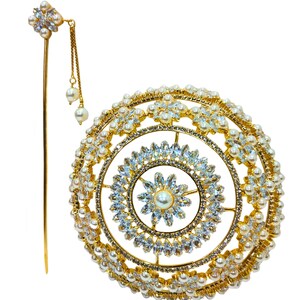 May include: A gold-coloured hair accessory set featuring a circular headpiece and a hairpin. The headpiece is decorated with clear crystals, faux pearls, and a central pearl. The hairpin has a floral design and dangling pearls.