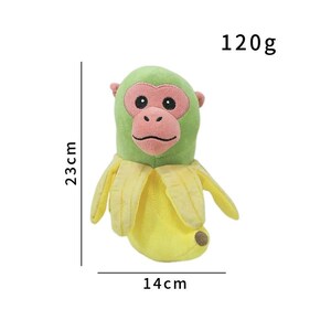 K&ouml;nnte beinhalten: Ein Pl&uuml;schtier in Form einer Banane mit einem Affengesicht. Das Spielzeug ist gr&uuml;n und gelb, mit rosa Akzenten. Es ist 23 cm hoch und 14 cm breit und wiegt 120g.
