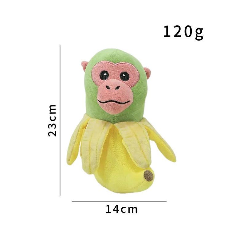 K&ouml;nnte beinhalten: Ein Pl&uuml;schtier in Form einer Banane mit einem Affengesicht. Das Spielzeug ist gr&uuml;n und gelb, mit rosa Akzenten. Es ist 23 cm hoch und 14 cm breit und wiegt 120g.